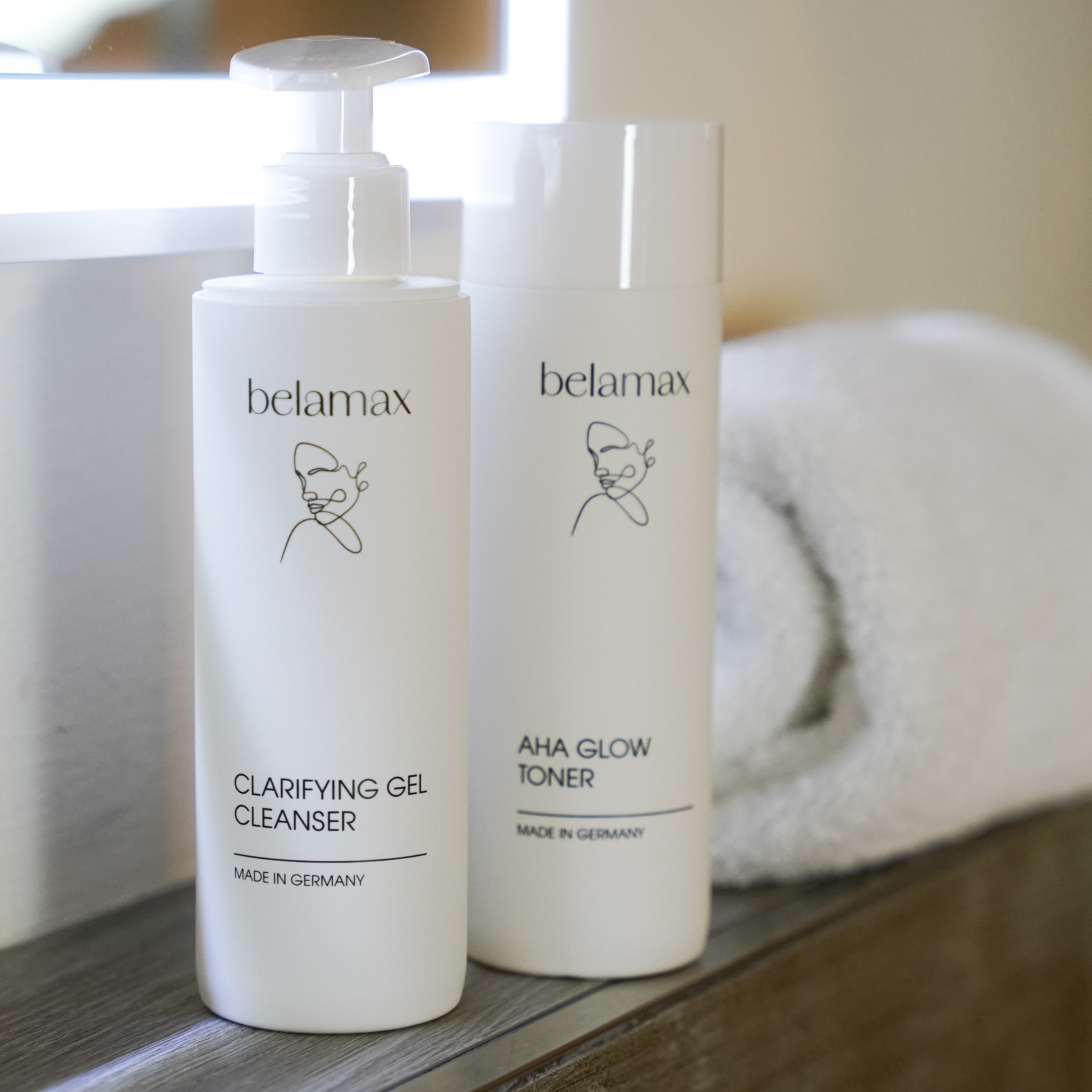Belamax Clarifying Gel Cleanser und AHA Glow Toner auf einem eleganten Badetisch, ideal für eine effektive Gesichtsreinigung.